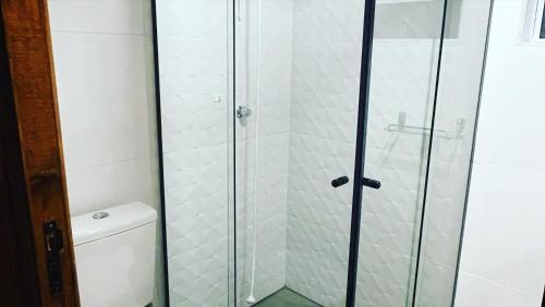 a shower with a glass door in a bathroom at Pousada Invernada in São Joaquim