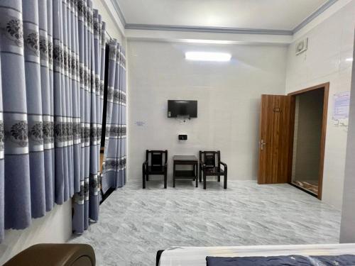 ein Zimmer mit Tisch und Stühlen und einem Fernseher in der Unterkunft Thiên Tân Motel 2 in Quảng Ngãi