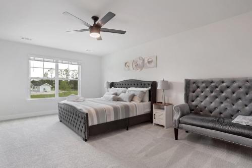 ein Schlafzimmer mit einem Bett mit Deckenventilator und einer Couch in der Unterkunft Perfect spot for Savannah vacation! in Port Wentworth