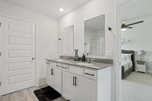 ein weißes Badezimmer mit Waschbecken und Spiegel in der Unterkunft Perfect spot for Savannah vacation! in Port Wentworth