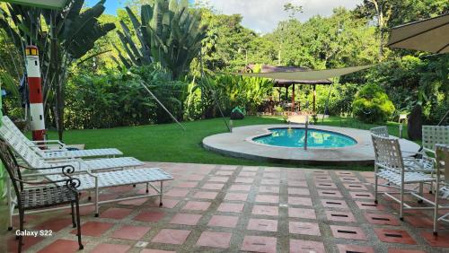 un patio con dos sillas y una piscina en Yethan house, en Uvita