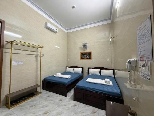 a room with two beds and a phone at Thiên Tân Motel 2 in Quang Ngai