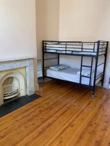 a room with two bunk beds next to a fireplace at Bozo backpacker in Melbourne