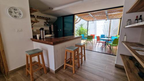 a kitchen with a counter and stools in a room at Hotel La Caracola Salento in Salento