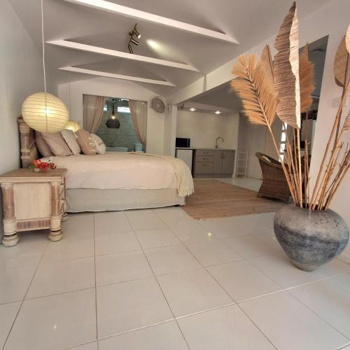 a bedroom with a bed and a vase with a plant at Studio Casablanca in Nelly Bay