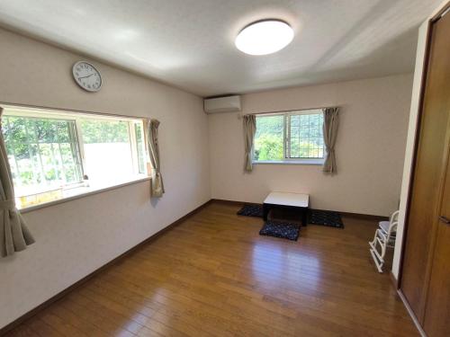 an empty room with a table and two windows at 山の湯 in Wada