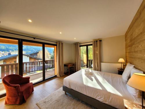 a bedroom with a large bed and a large window at Chalet familial rénové, proche centre, capacité 12, parking, WiFi - FR-1-598-195 in Les Gets