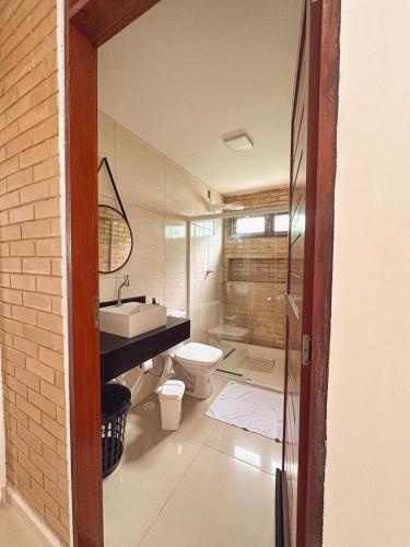 a bathroom with a toilet and a sink at Encanto à Beira-Mar com piscina no Pontal de Coruripe in Coruripe