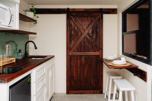 a kitchen with a barn door in the wall at Desierto de Acero Containers in San José del Cabo