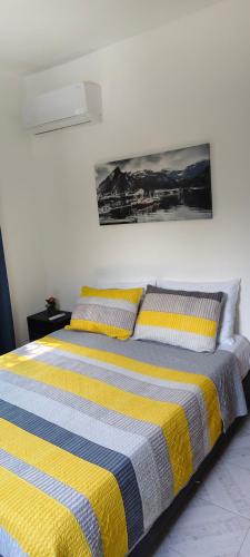 a bedroom with a bed with yellow and blue stripes at Departamento Familiar Escorpións in Tuxtla Gutiérrez