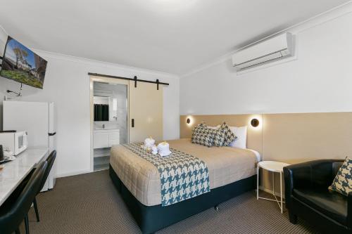 a hotel room with a bed and a couch at Kandos Fairways Motel in Kandos