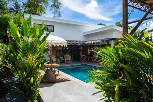 a swimming pool in front of a villa at Manao Pool Villa 2 - 5 Mins Walk To The Beach in Ko Lanta