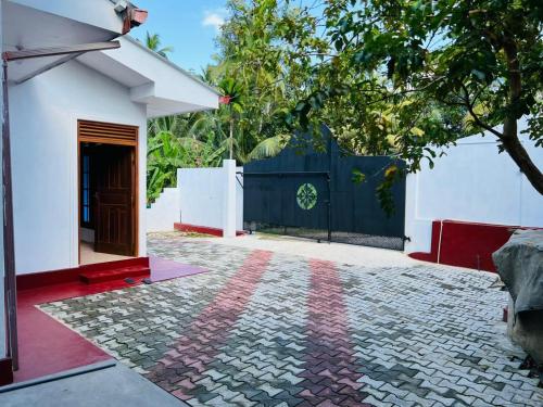 a house with a fence and a driveway at Ranathunga Guest House in Ginimellagaha West