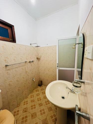 a bathroom with a sink and a mirror at Ranathunga Guest House in Ginimellagaha West