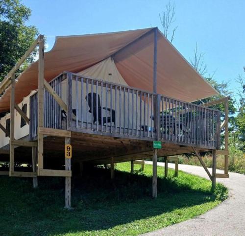 een grote tent met een terras in het gras bij Sensational Tented Cabin Nestled Amidst Trees and Fire Pit Provided in Logan, Ohio in Logan