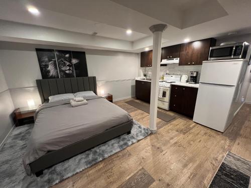 a bedroom with a bed and a white refrigerator at Modern, basement apartment, close to airport in Toronto
