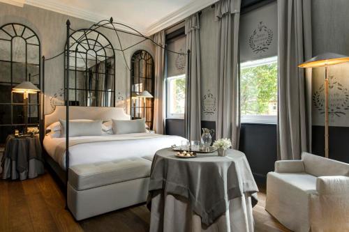 a bedroom with a bed and a table and a chair at The Franklin London - Starhotels Collezione in London