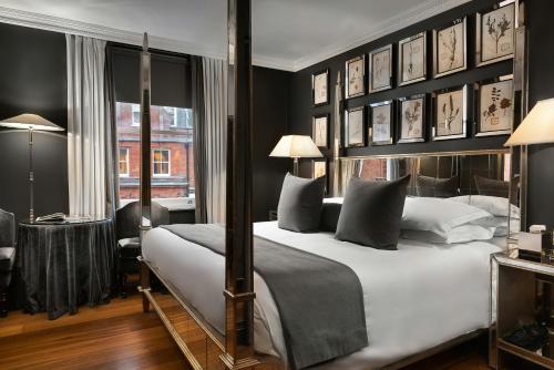 a bedroom with a large bed with black walls at The Franklin London - Starhotels Collezione in London