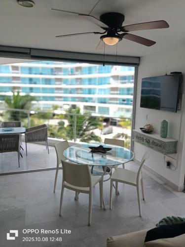 a dining room with a table and chairs and a large window at Condominios Acqua, Nuevo Vallarta in Nuevo Vallarta