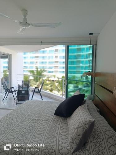 a bedroom with a large bed and a large window at Condominios Acqua, Nuevo Vallarta in Nuevo Vallarta