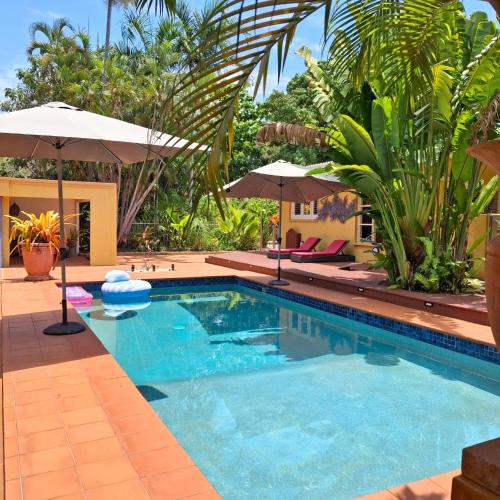 a swimming pool in a resort with umbrellas at Studio Casablanca in Nelly Bay