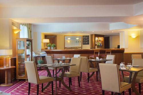 a restaurant with tables and chairs and a bar at Starhotels Business Palace in Milan