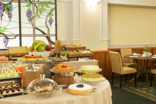 un buffet con muchos tipos diferentes de comida en las mesas en Starhotels Business Palace, en Milán