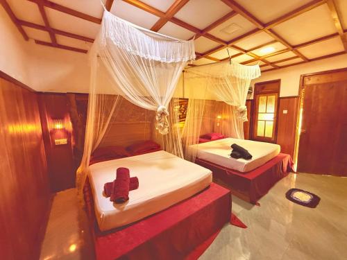a bedroom with two beds with mosquito nets at Maika safari lodge in Udawalawe