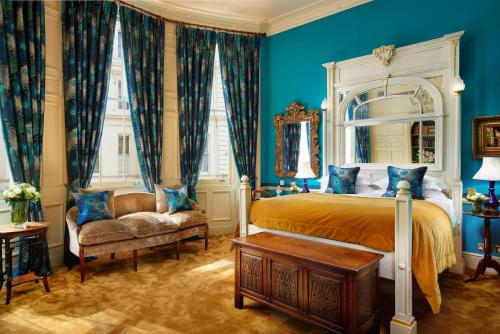a blue bedroom with a bed and a chair at The Gore London - Starhotels Collezione in London