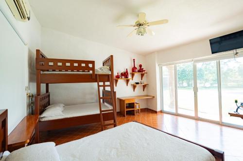 Un dormitorio con dos literas y un ventilador de techo. en Large House with Pool in Yautepec, 4 Bedrooms, en Yautepec