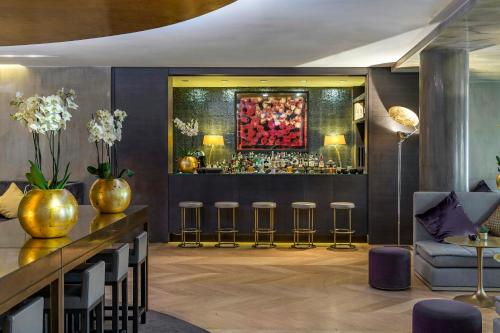 een lobby met een bar met krukken bij Rosa Grand Milano - Starhotels Collezione in Milaan