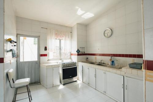 Una cocina con un fregadero y un reloj en la pared. en Large House with Pool in Yautepec, 4 Bedrooms, en Yautepec