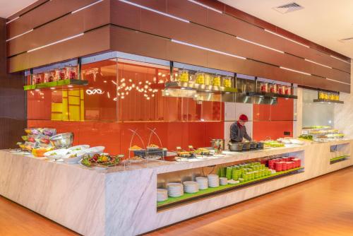 湛江湛江人民大道希尔顿欢朋酒店Hampton by Hilton Zhanjiang Renmin Avenue的厨师在厨房里准备餐厅的食物