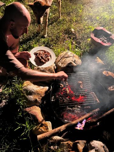 a man cooking food on top of a grill at Yidan Farmstay in Chiang Dao in Ban Mae Khon