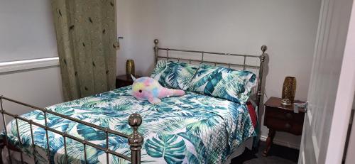 a teddy bear sitting on a bed in a bedroom at Aeris Holiday Home Flinders NSW Pet Friendly in Croom