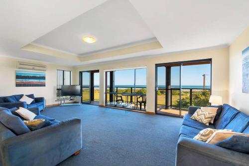 a living room with two blue couches and a view of the ocean at Coast View - 39b Hargreaves - Family - Beach - No Linen Included in Middleton