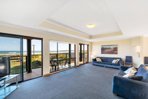 a living room with a blue couch and a television at Coast View - 39b Hargreaves - Family - Beach - No Linen Included in Middleton