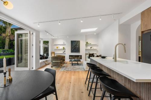 a kitchen and living room with a counter and chairs at Luxury Ponsonby Villa in Auckland