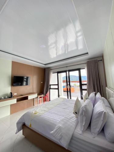 a bedroom with a large bed with white sheets and pillows at Gayo Belangi Resort in Tretet