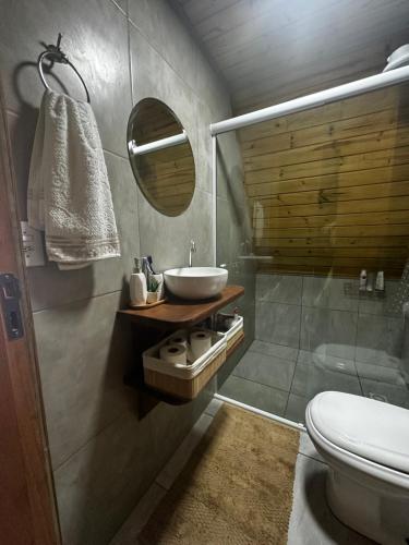 a bathroom with a sink and a toilet and a mirror at A-Frame da Lagoa in Imaruí