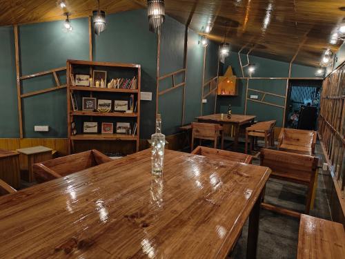 a dining room with a wooden table and wooden chairs at HimWanderer Camps & Cottages Pangot in Nainital