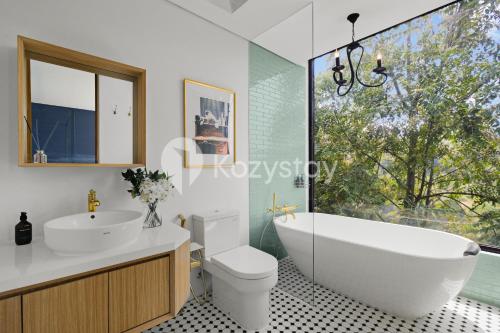une salle de bain avec une baignoire, des toilettes et un lavabo dans l'établissement Marjara Villa by Kozystay - Dago, à Ciburial