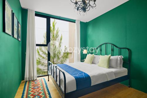 une chambre avec des murs verts et un lit avec une fenêtre dans l'établissement Marjara Villa by Kozystay - Dago, à Ciburial