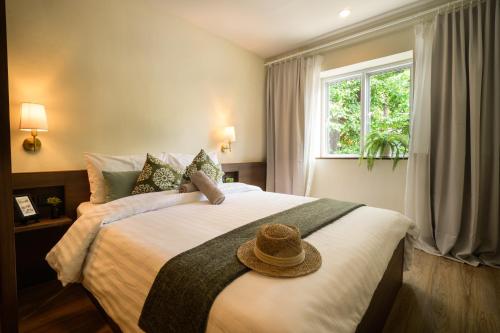 a bedroom with a large bed with a hat on it at Niras Bankoc Hostel in Bangkok