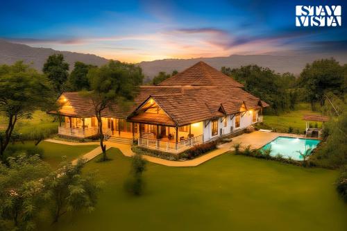 an aerial view of a house with a swimming pool at StayVista at Orchard by the River with Bonfire, BBQ in Karjat