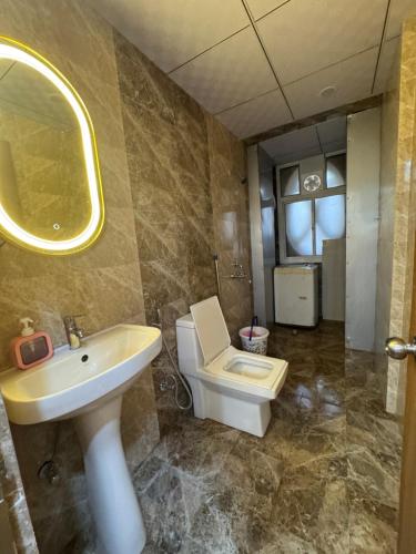 a bathroom with a sink and a toilet and a mirror at Hideaway Nest in Ghaziabad