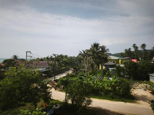 a view of a street with palm trees and houses at StayStable Guest House in Ko Lanta Yai