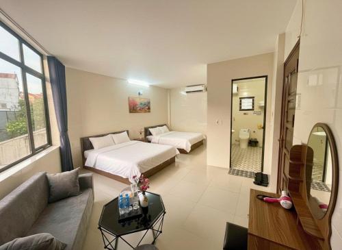 a hotel room with two beds and a couch at Hana House in Kỳ Lừa