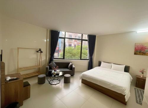 a bedroom with a bed and a chair and a window at Hana House in Kỳ Lừa