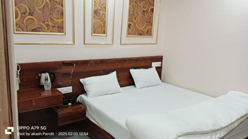 Un dormitorio con dos camas y un teléfono sobre una mesa. en Hotel Shri Ram Anadam Inn, en Masodha